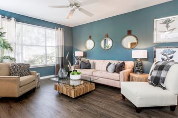 A living room with blue walls and a ceiling fan